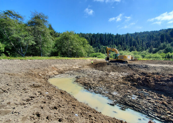 crew excavating a section of a creek channel