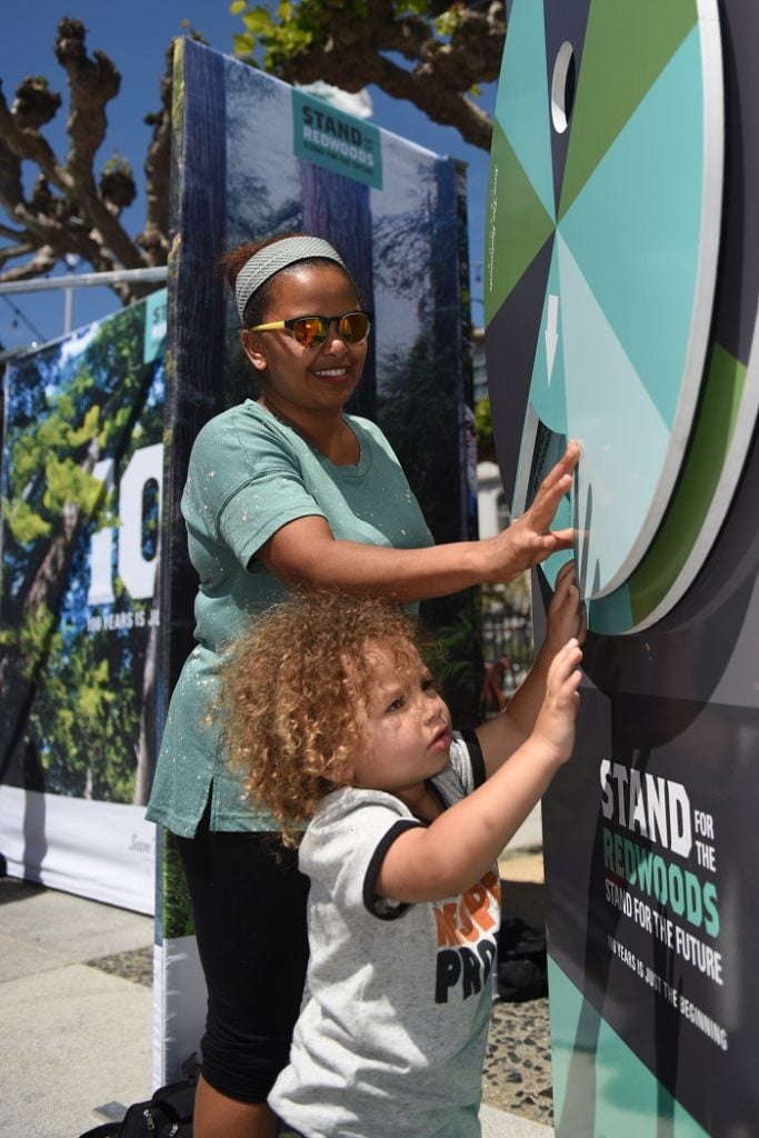 Selam Jaser and her son Zachary learn about the plants and animals of the redwood forests in our new interactive booth. Photo by Paolo Vescia