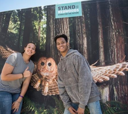 Festival-goers Macari Dawson and Cameron Dyal pose with a northern spotted owl at the League’s booth. Photo by Paolo Vescia