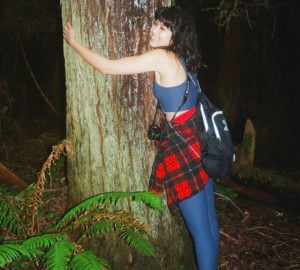 A woman hugs a redwood tree