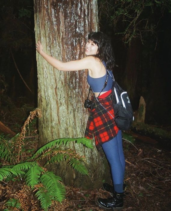 A woman hugs a redwood tree