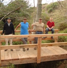 Joseph Haas (in red shirt) with team members and the bridge they built.