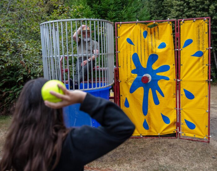 A person prepares to throw a ball at a dunk tank