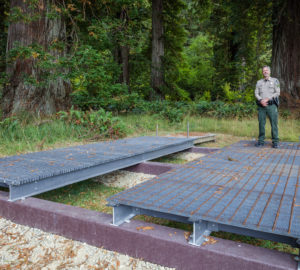 Brett Silver, California State Parks Acting Sector Superintendent, stands on design samples for the elevated walkway which will provide visitor access to the Grove of Titans while protecting the sensitive habitat. Photo by Max Forster, @maxforsterphotography.