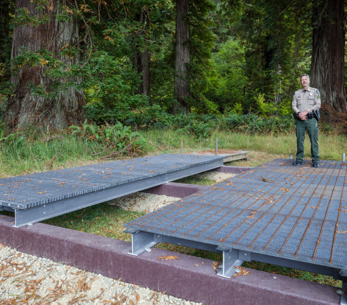 Brett Silver, California State Parks Acting Sector Superintendent, stands on design samples for the elevated walkway which will provide visitor access to the Grove of Titans while protecting the sensitive habitat. Photo by Max Forster, @maxforsterphotography.