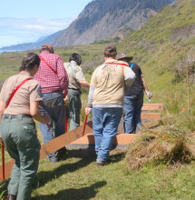 Hardworking volunteers carry lumber to a bridge site. Photo courtesy of the Haas family