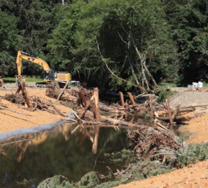 A construction site with a large excavator and a pond