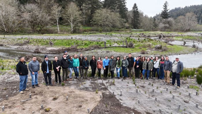 26 people standing outside in the floodplains of Prairie Creek