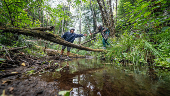 Jaime Boggs and Dana Viloria crossing a creek at Fish Run Place