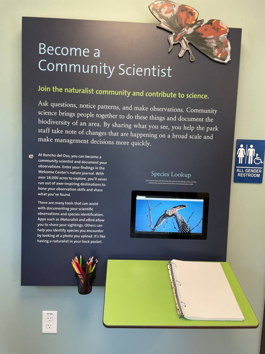 A sign describes how to be a community scientist. A journal and pencils are at the bottom