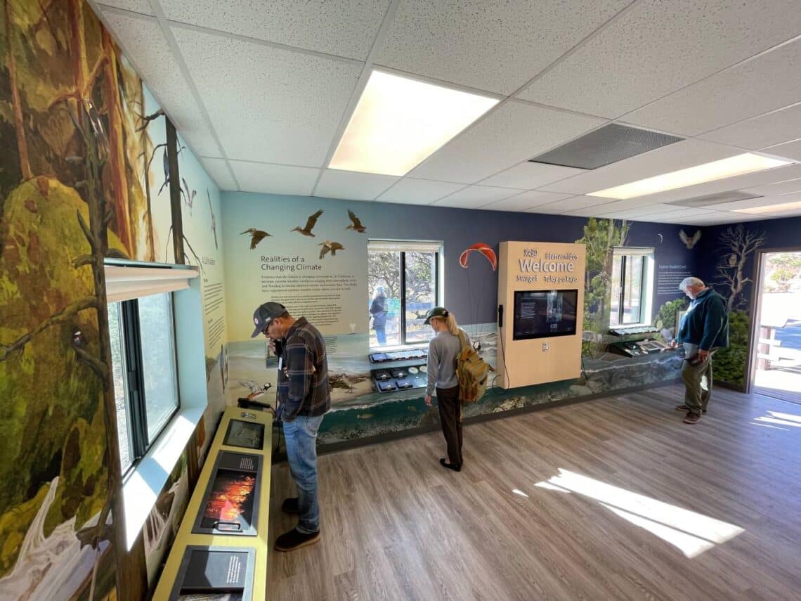 Three people look at exhibits