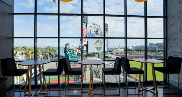 Hight top tables and chairs overlook a baseball field and stadium