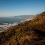 landscape vista of the rugged coastline, covered in a thick blanket of redwood trees.