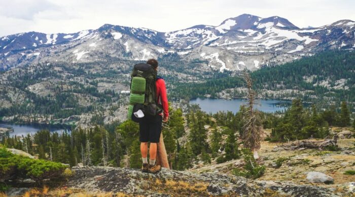 a backpacker looks out over a high sierra landscape