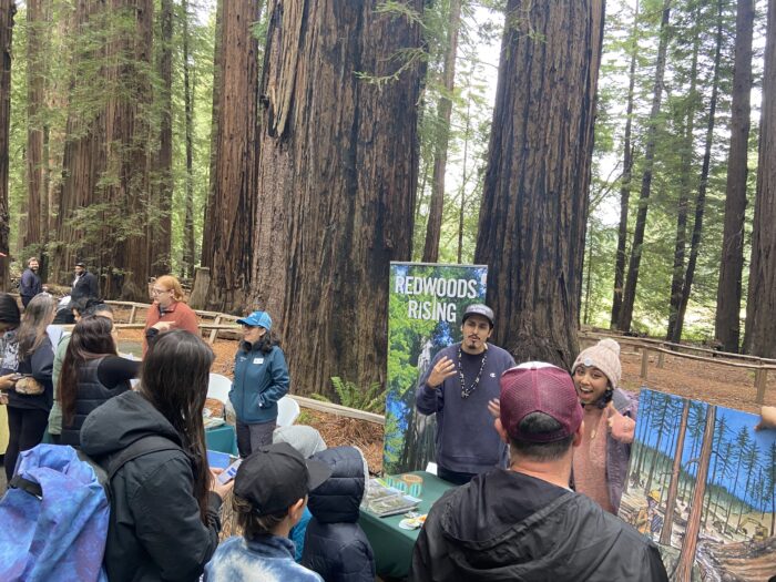 People crowd around tables staffed by Save the Redwoods League and Redwoods Rising.