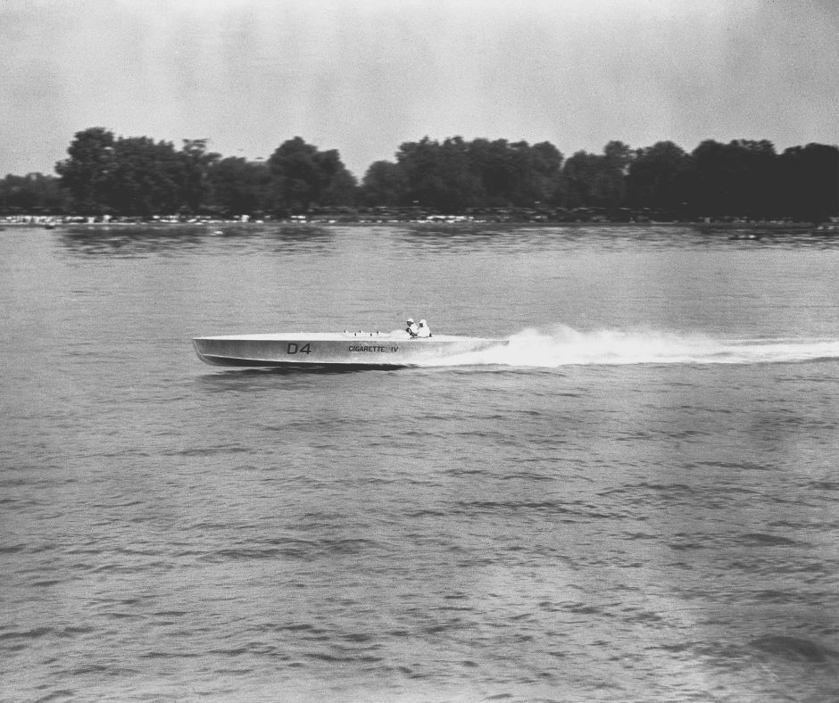 Black and white photo of motorboat on a lake.