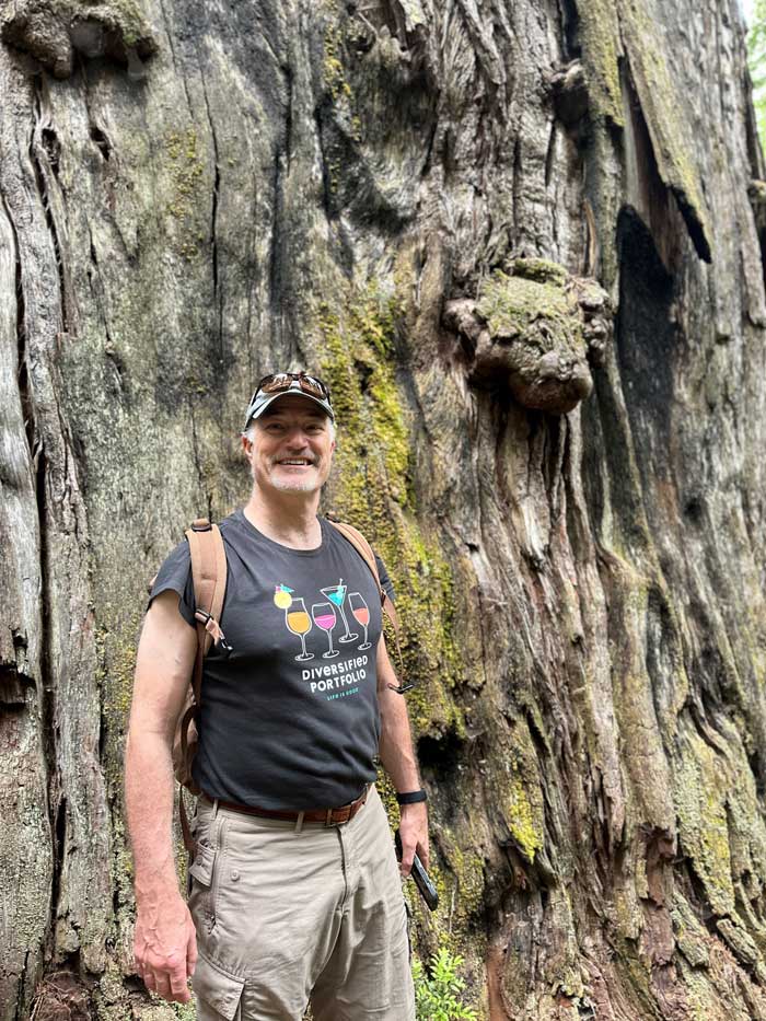 Daen Wombwell standing in front of an ancient redwood tree.