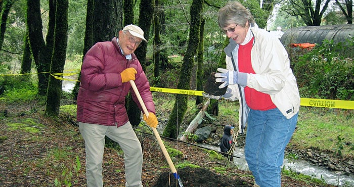 Forest restoration includes planting seedlings. Here, longtime League members Thurston Womack and Charlotte Cranmer pitch in.