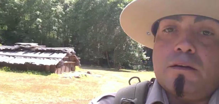 A close-up still frame of naturalist interpreter Skip Lowry, in his ranger fatigues, out in the field presenting a livestream naturalist program. 